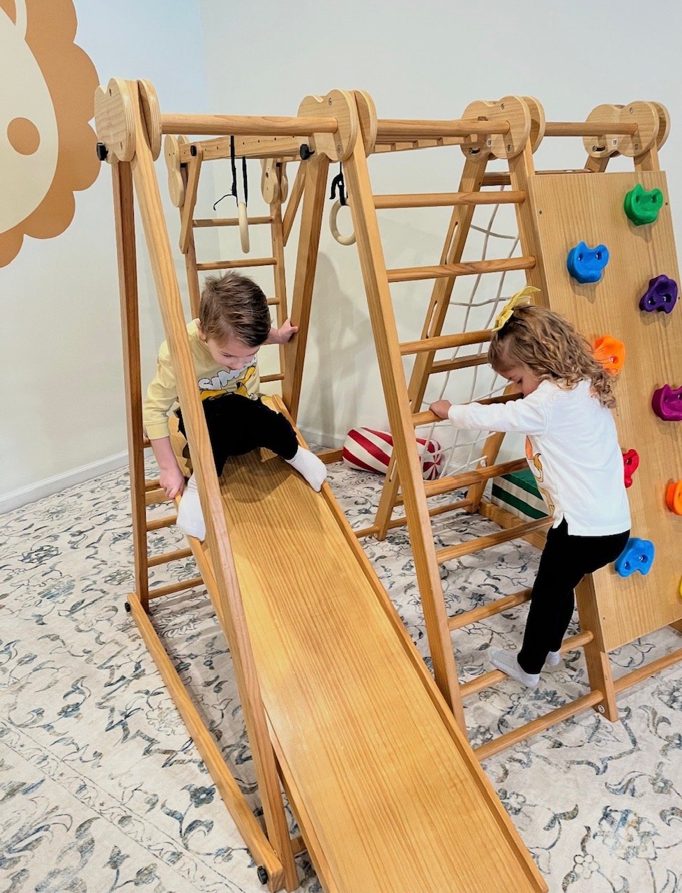 Children exploring the wooden climbing and slide area